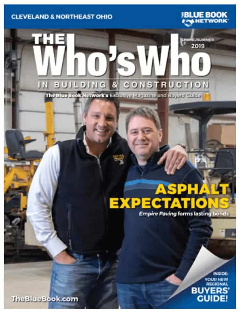 Two men stand smiling with arms around each other in a workshop, featured on the cover of a building and construction magazine titled “The Who’s Who.” Headline reads “Asphalt Expectations,” highlighting Ohio paving and construction expertise. Equipment is visible behind them.