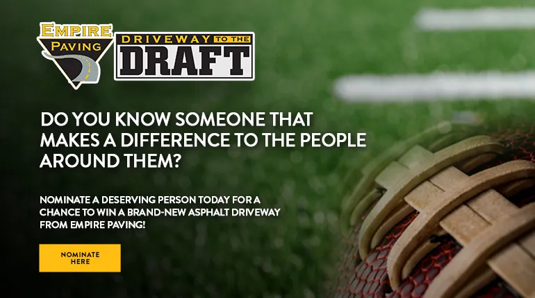 Close-up of a football on turf with text promoting Empire Pavings Driveway to the Draft contest, inviting nominations for someone to win a new asphalt driveway. A yellow Nominate Here button is visible.